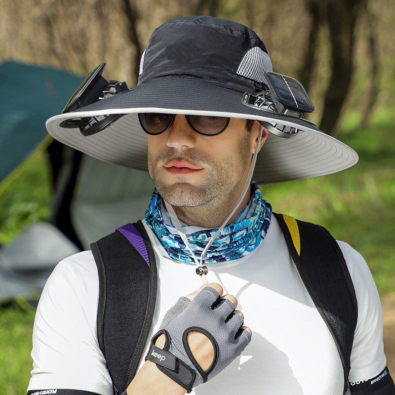 Man wearing a wide-brimmed hat, sunglasses, and a Jeep glove in an outdoor setting.