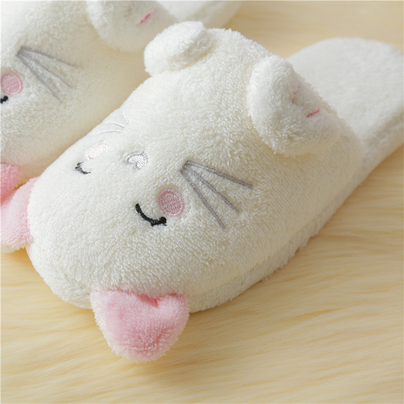 Plush slippers with a cat design on a wooden surface
