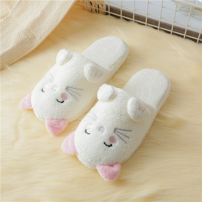 Pair of cartoon cat slippers on a wooden floor