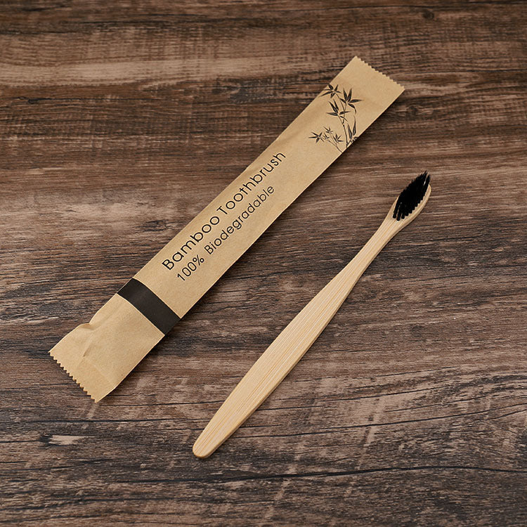Bamboo toothbrush with packaging on a wooden surface