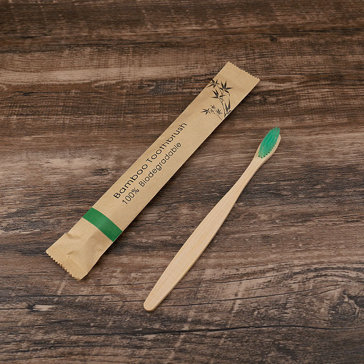 Bamboo toothbrush with packaging on a wooden surface