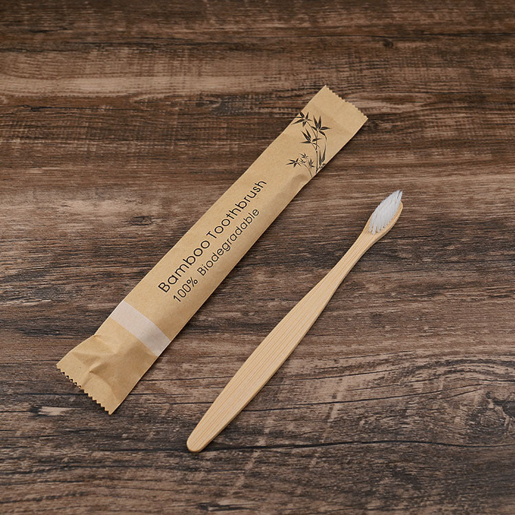 Bamboo toothbrush with packaging on a wooden surface