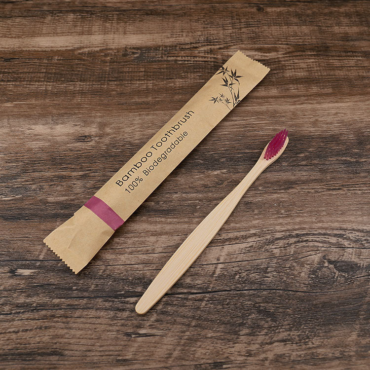Bamboo toothbrush with packaging on a wooden surface