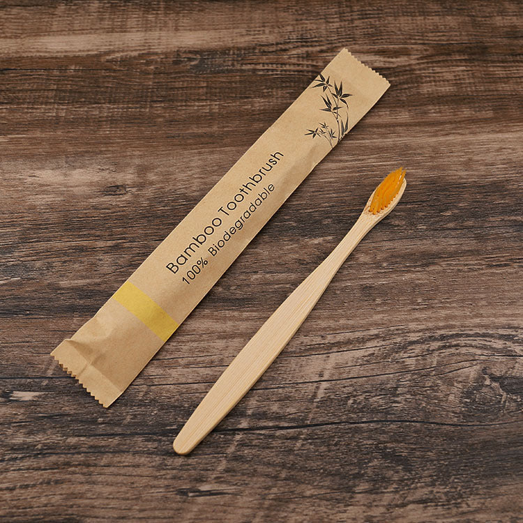 Bamboo toothbrush with packaging on a wooden surface