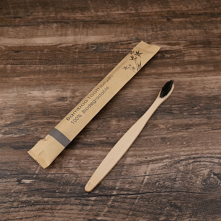 Bamboo toothbrush and packaging on a wooden surface