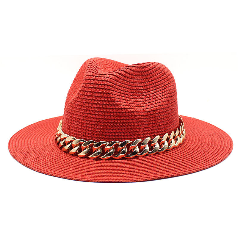 Red straw hat with gold chain detail on a white background