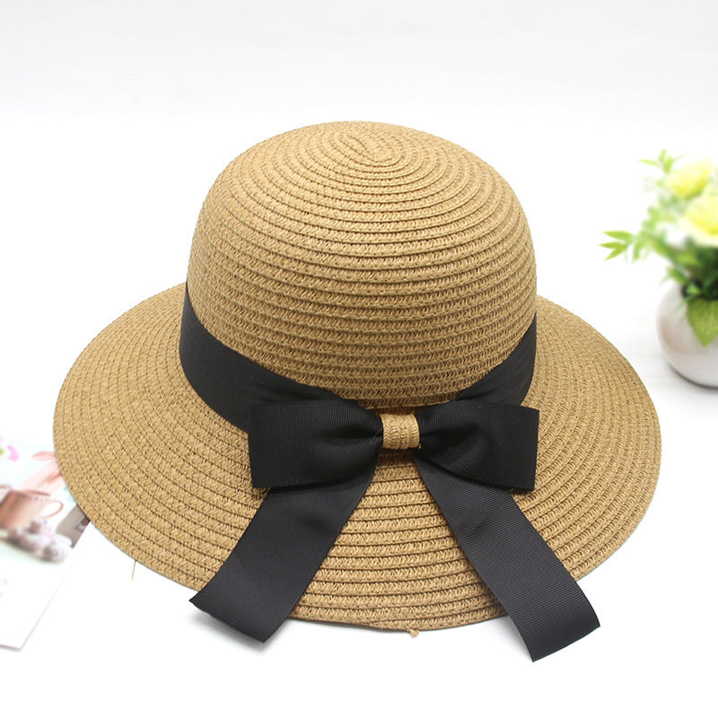 Beige straw hat with a black ribbon on a white background