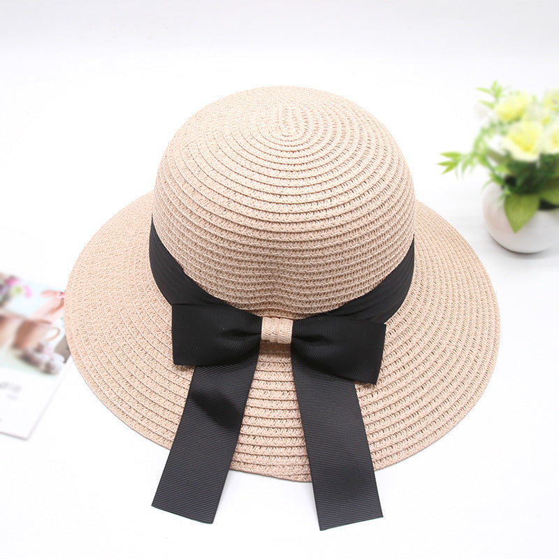 Beige straw hat with a black ribbon on a white background