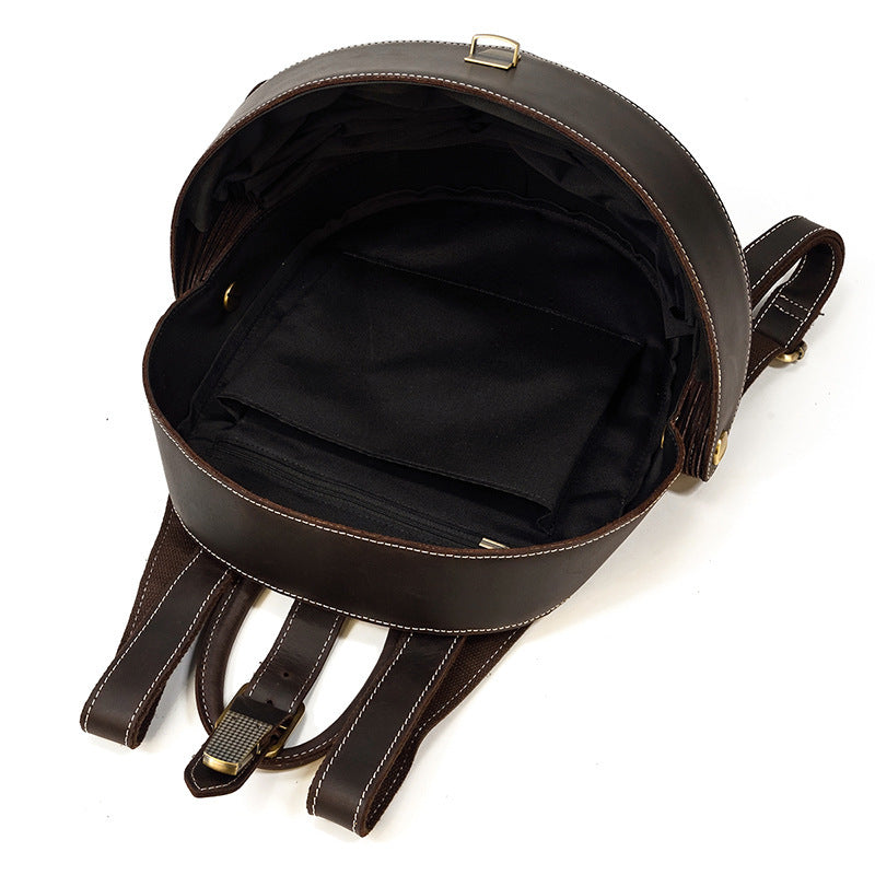 Stylish brown leather backpack with beetle-inspired design on a city street – ideal for travel and daily use