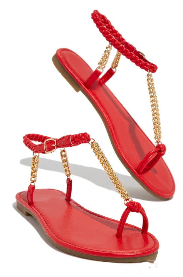 Red sandals with gold chains on a white background