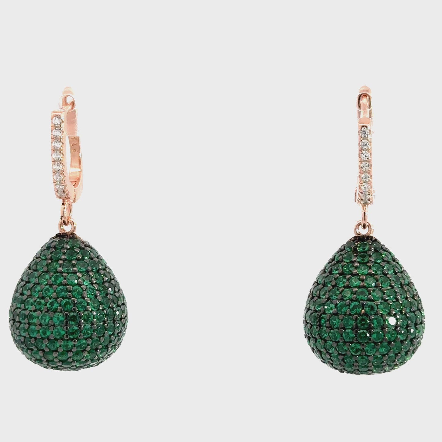 Green teardrop earrings with rose gold hooks on a light gray background