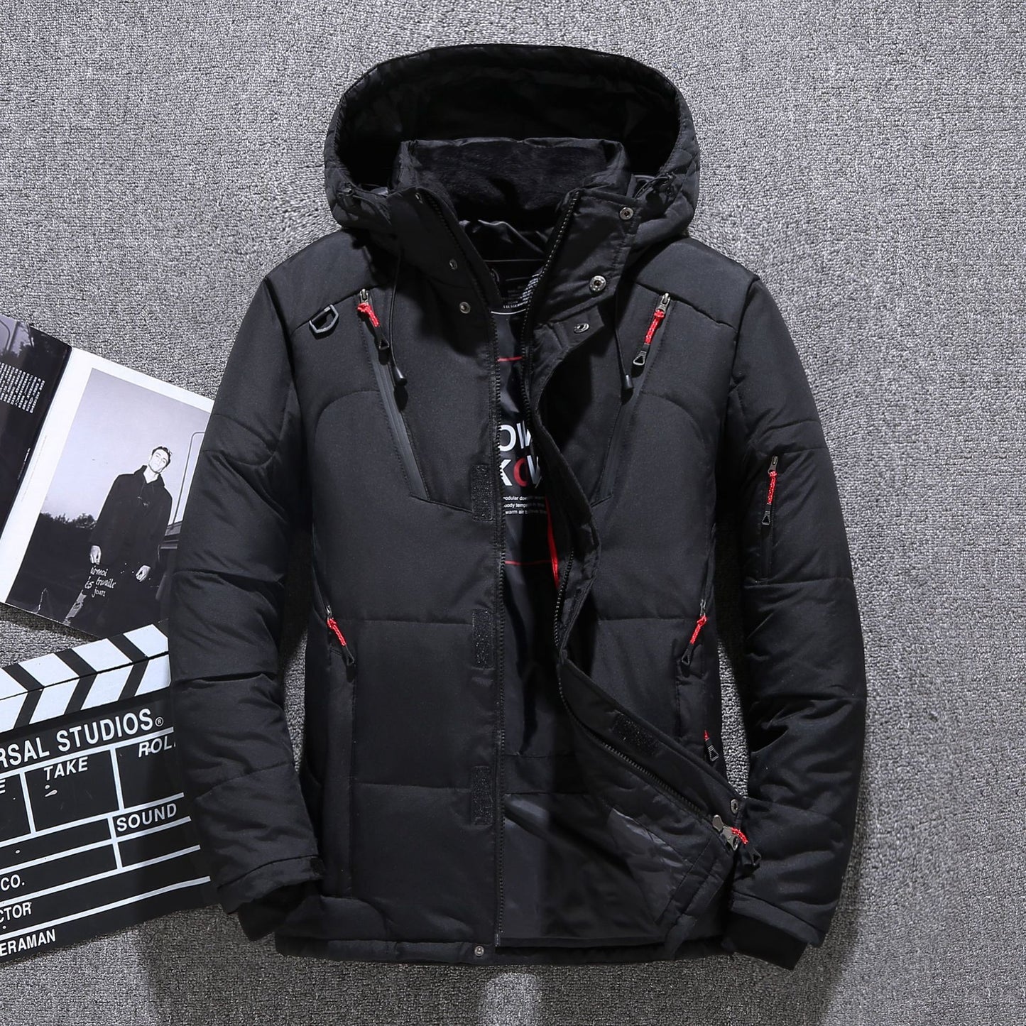 Black winter jacket with red accents on a gray textured background