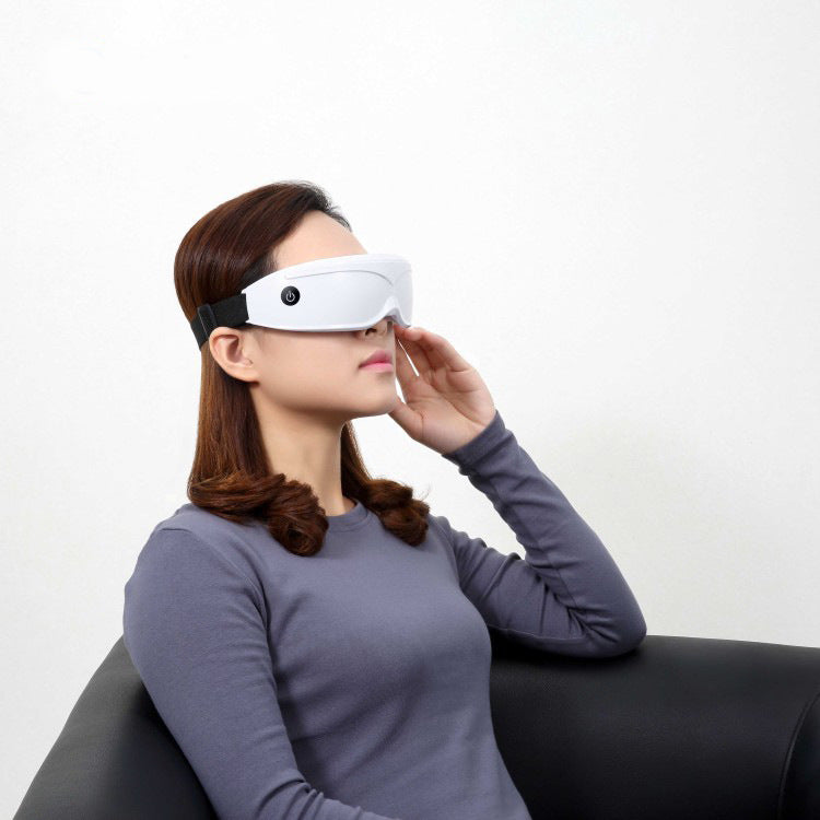 Woman wearing a white eye mask on a plain background