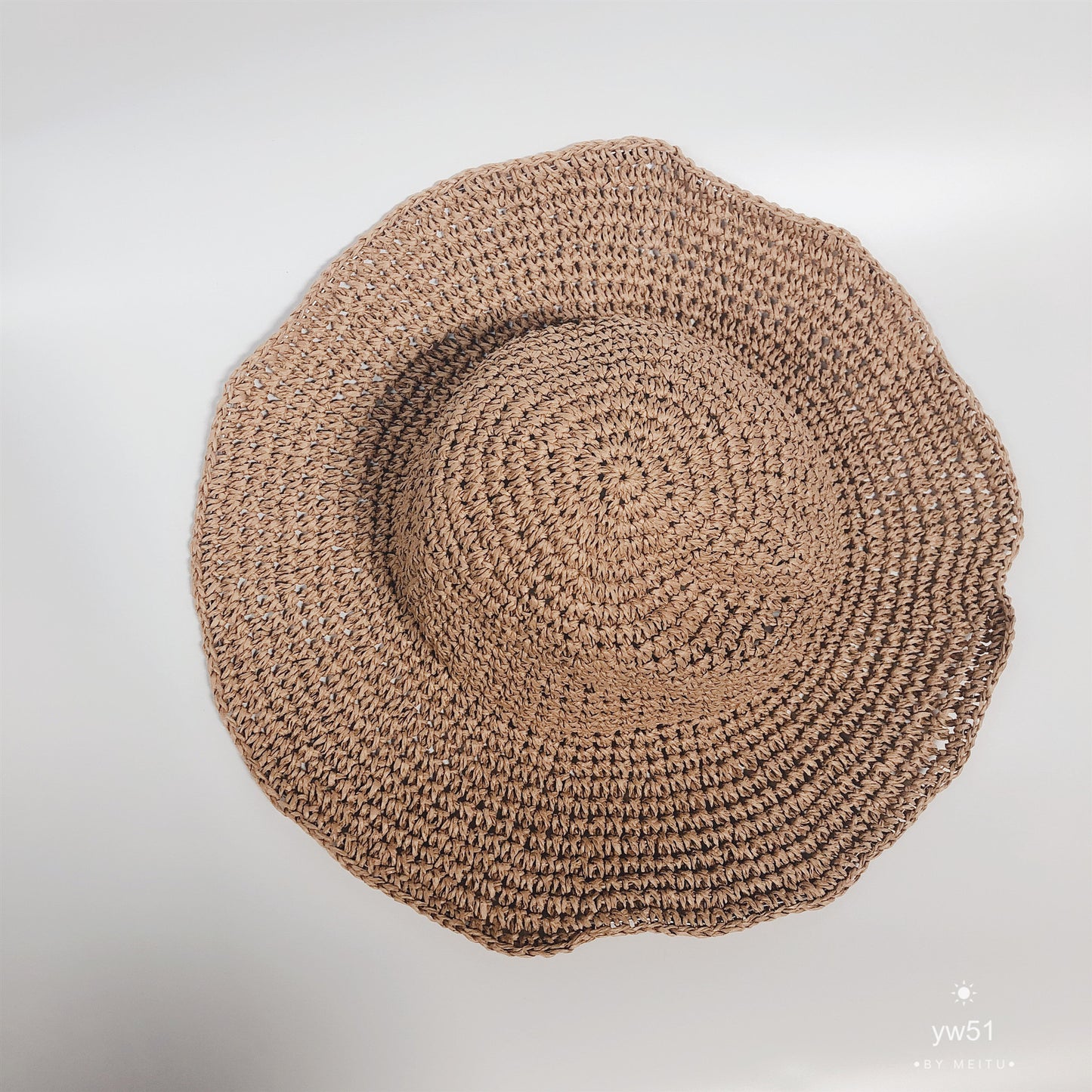 Brown woven hat on a light gray background
