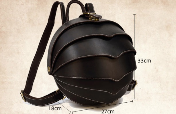 Stylish dark brown leather backpack with beetle-inspired design on a city street – ideal for travel and daily use