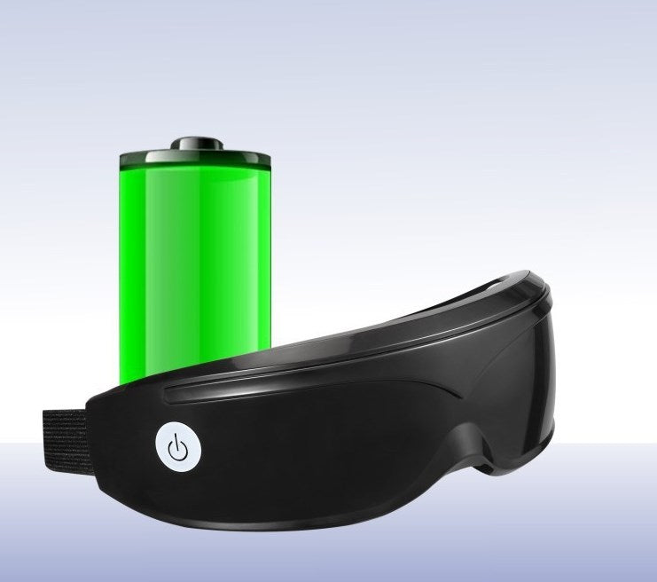 Black eye mask with green battery pack on a light gray background
