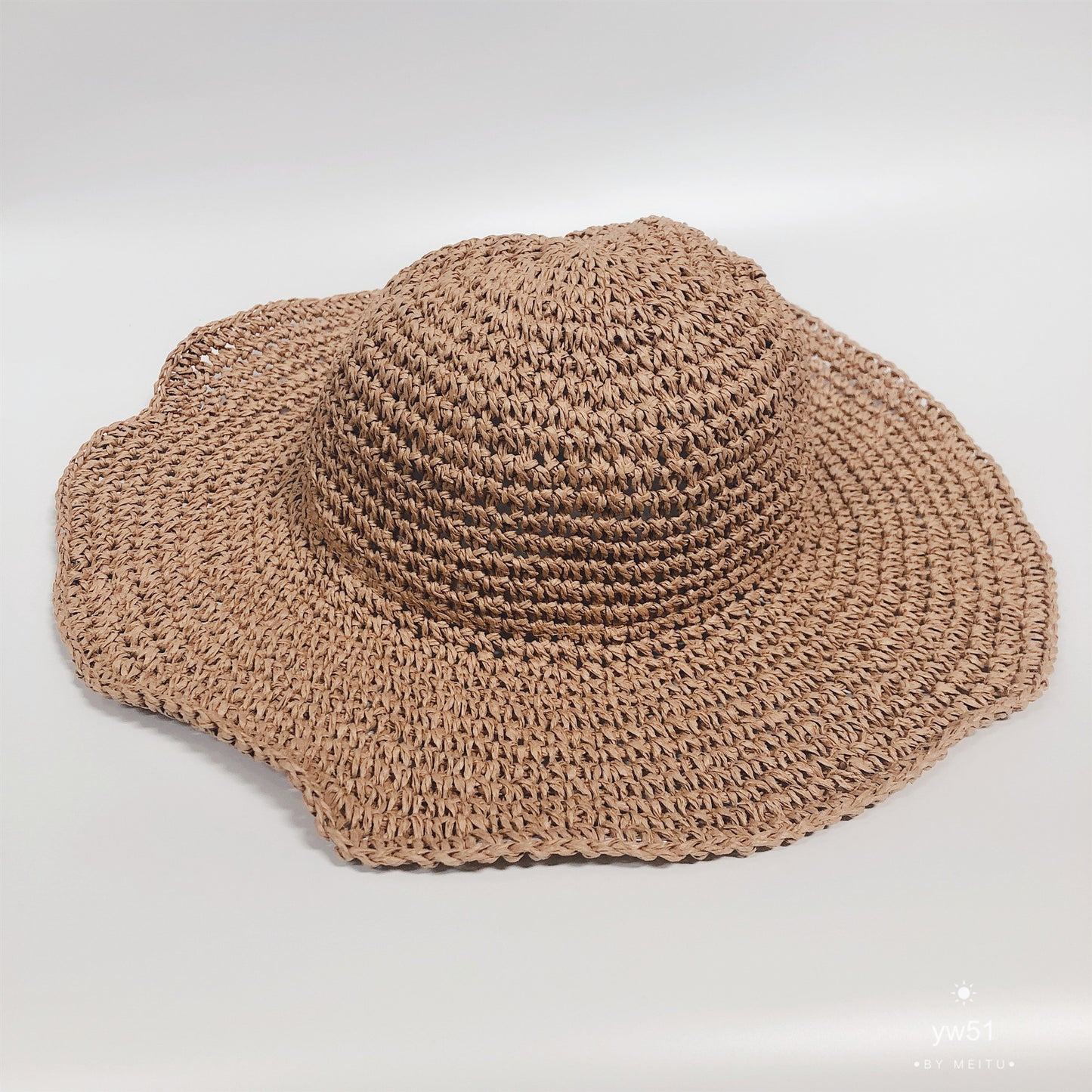Brown woven hat on a light gray background
