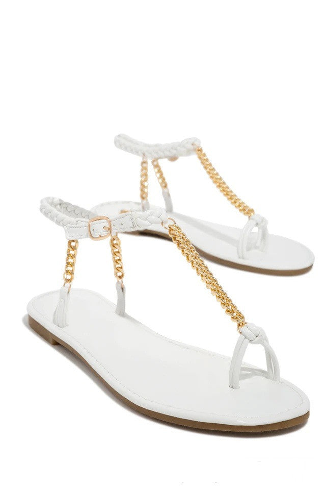 White sandals with gold chain details on a white background