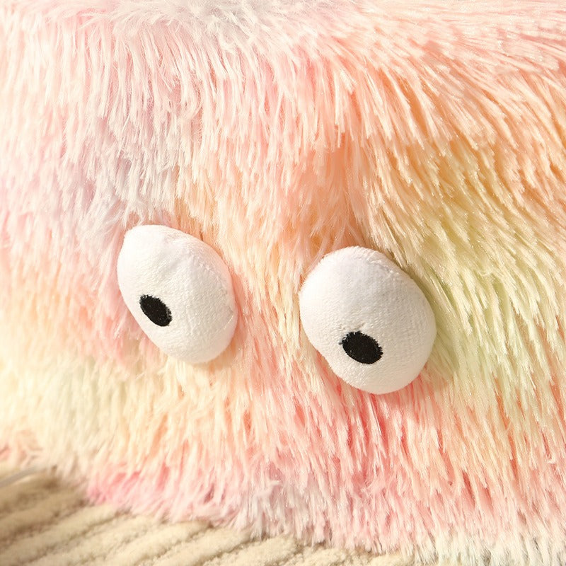 Close-up of a plush toy with large white eyes and pink fur.
