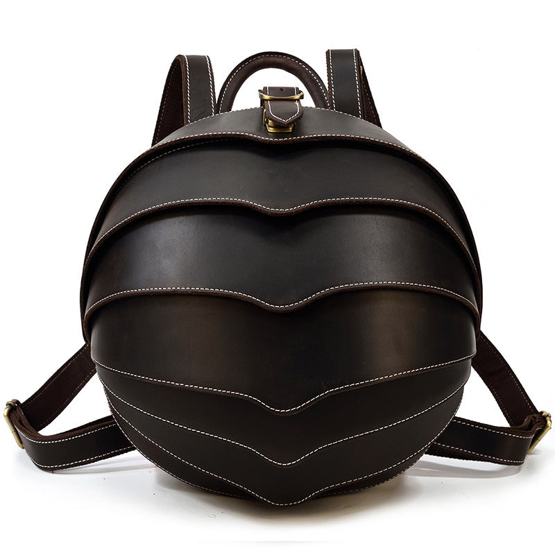 Stylish dark brown leather backpack with beetle-inspired design on a city street – ideal for travel and daily use