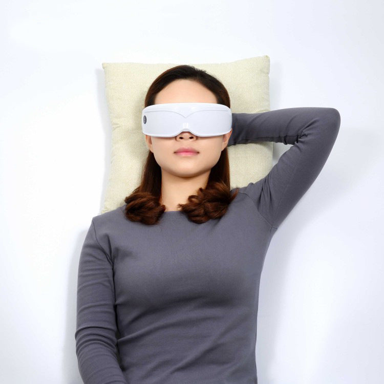 Woman wearing a white sleep mask on a white background