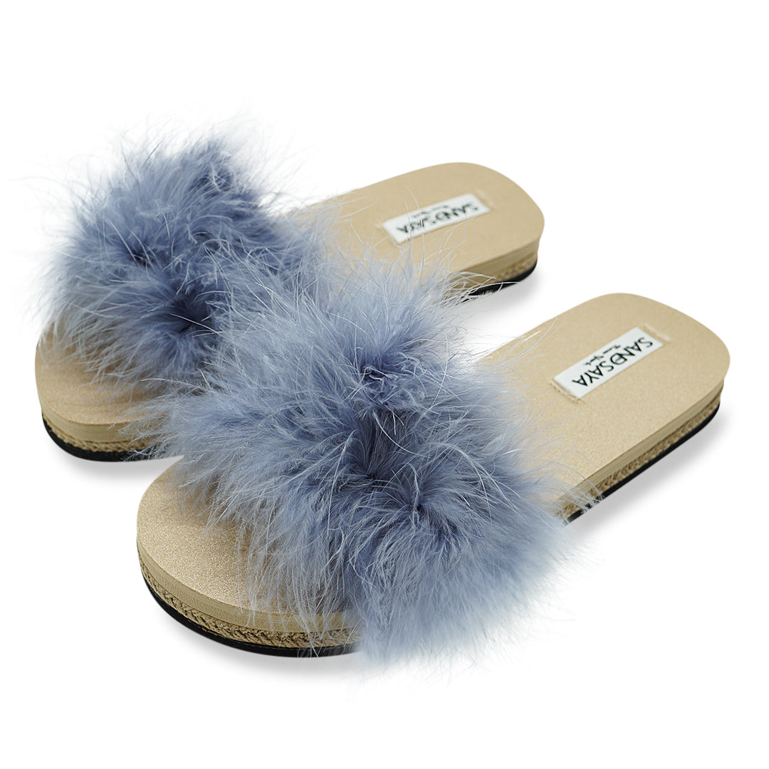 Pair of fluffy blue sandals with beige soles on a white background