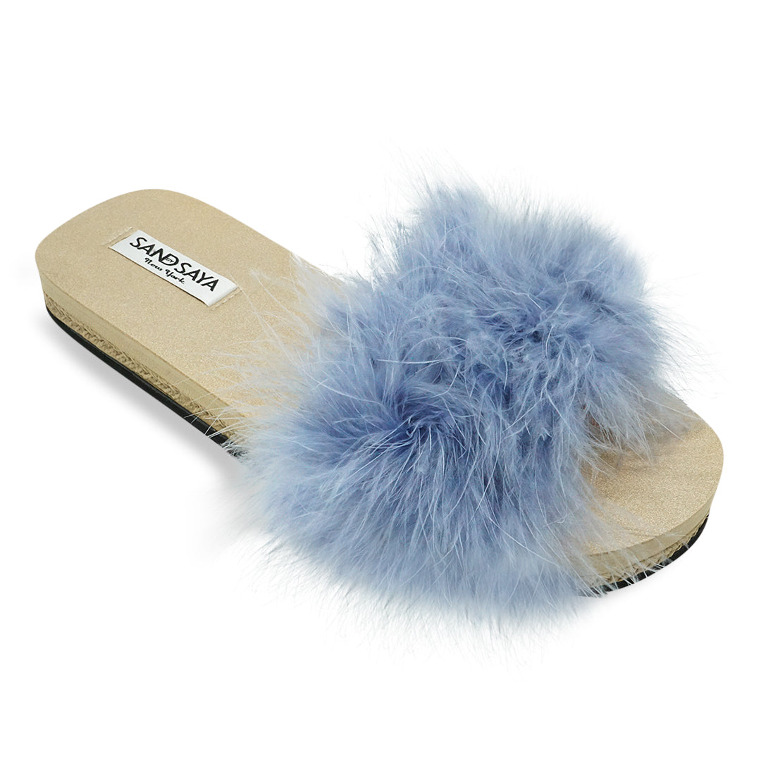 Blue fluffy slide sandal with a visible brand label on a white background