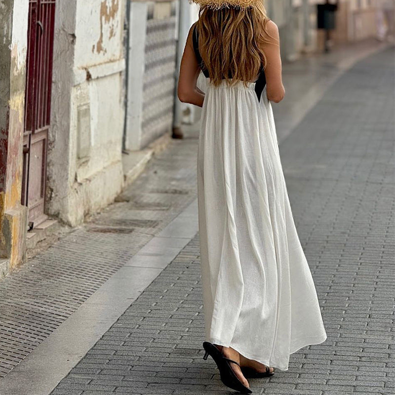 Woman in a long white dress walking down a street.