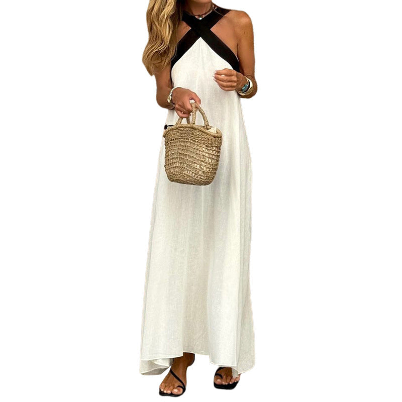 Woman wearing a white dress with black straps holding a straw bag on a white background