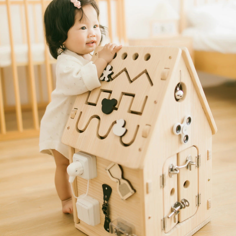 child interacting with a wooden activity house for early learning