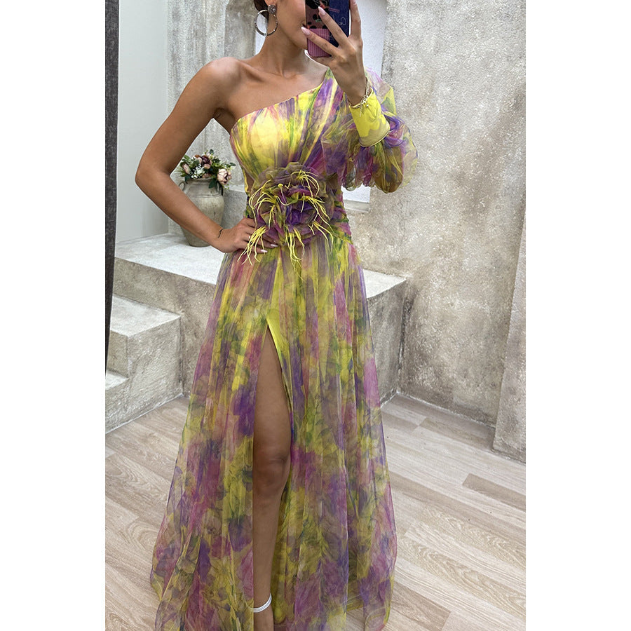 Woman taking a mirror selfie wearing a colorful floral dress in an indoor setting.