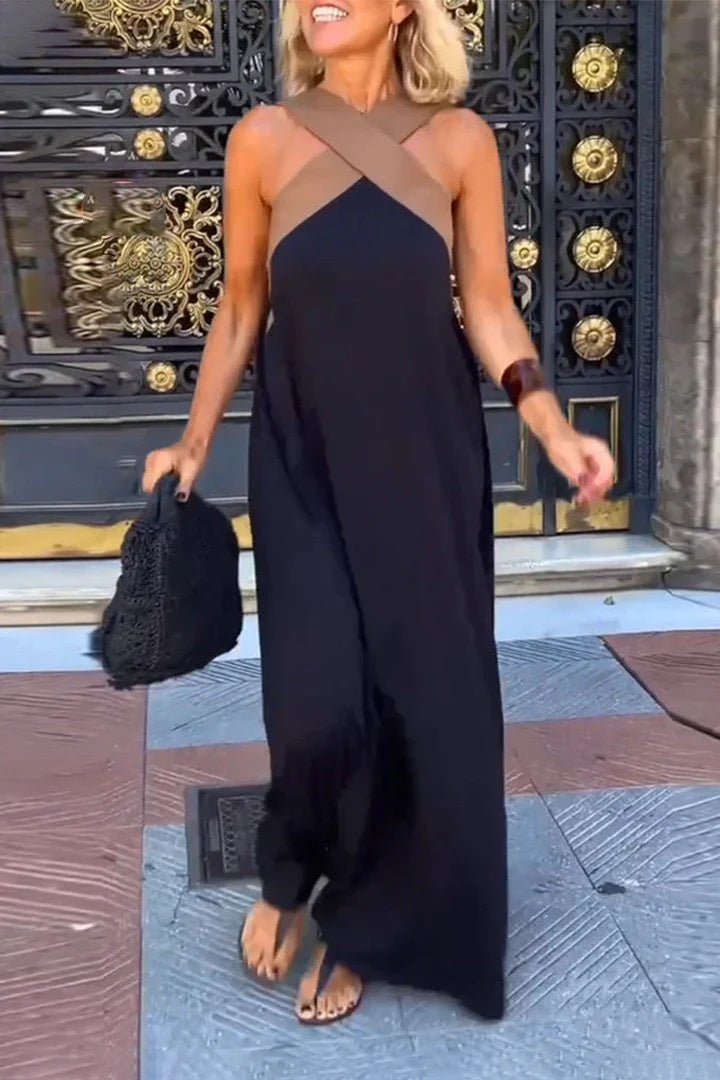 Woman in a black and brown dress standing in front of an ornate door.