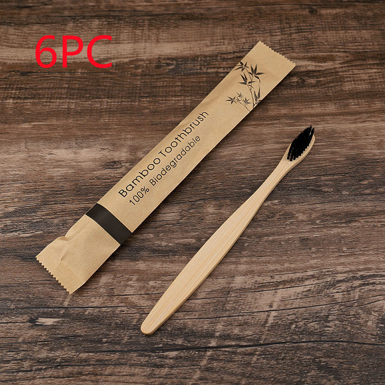 Bamboo toothbrush with packaging on a wooden surface, labeled as '6PC' and '100% Biodegradable'.