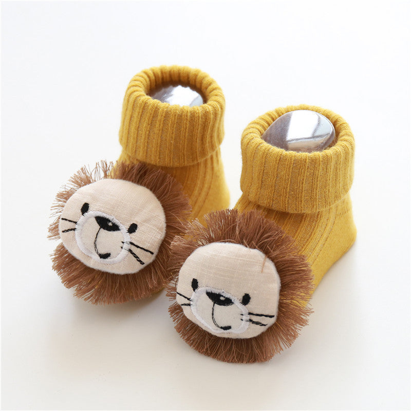 Yellow baby booties with lion face designs on a white background
