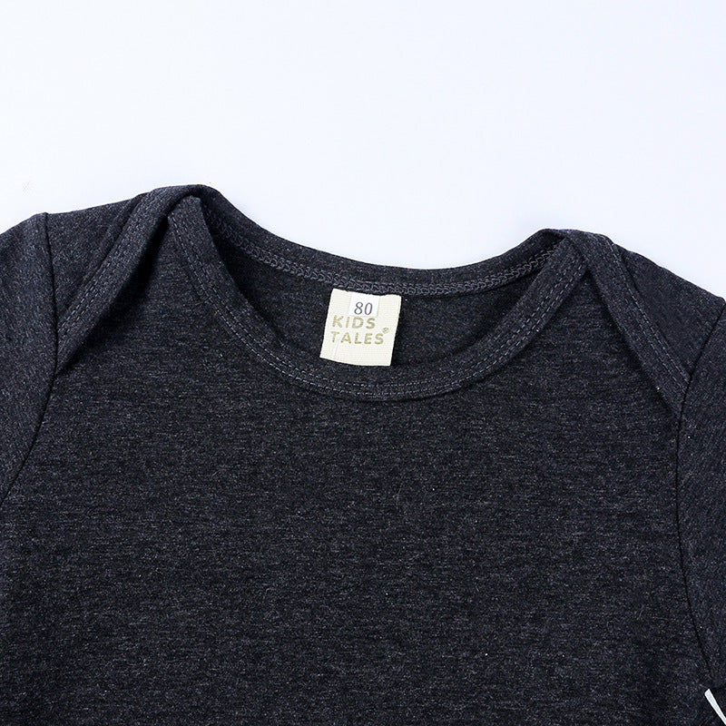 Dark gray baby onesie with a brand label on a light gray background