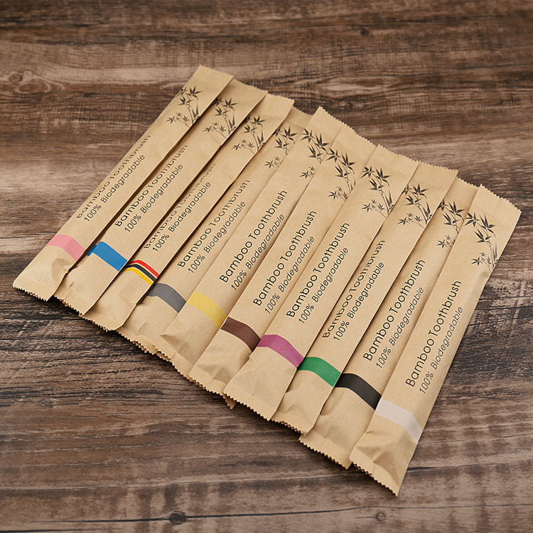 Set of bamboo toothbrush packaging on a wooden surface
