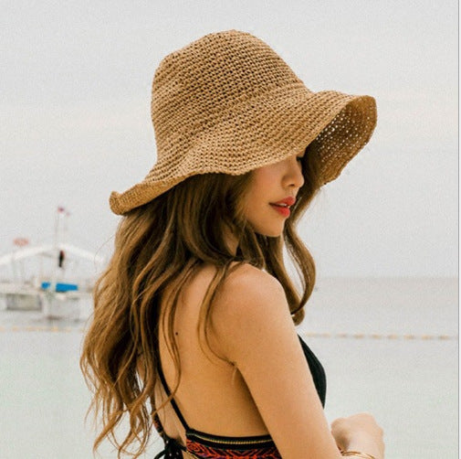 Woman wearing a straw hat by a body of water