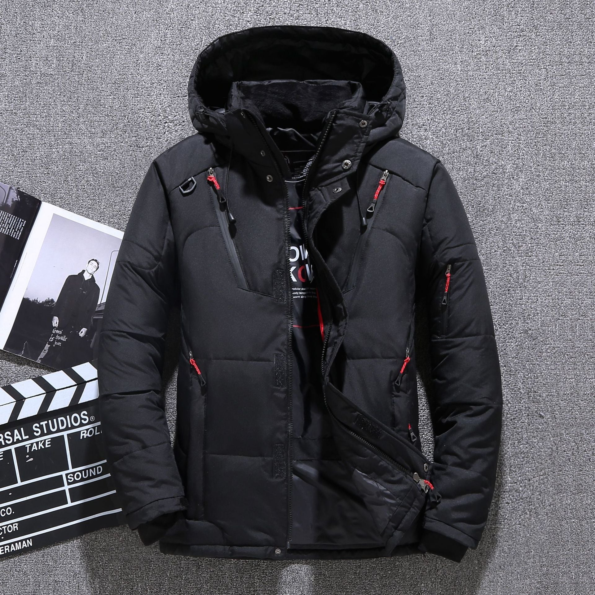 Black winter jacket with red accents on a gray textured background