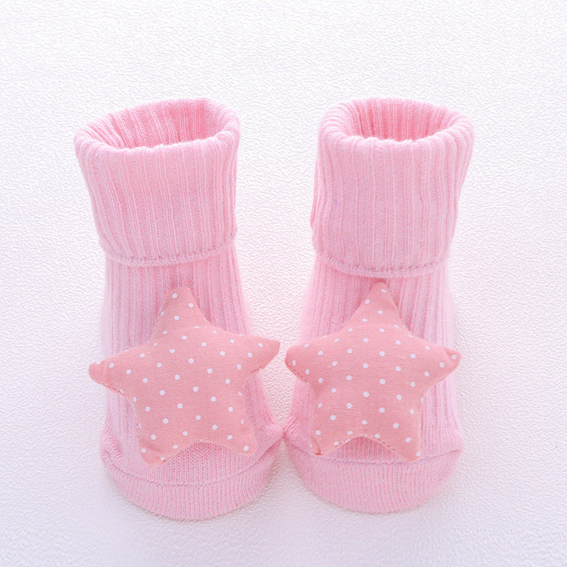 Pink baby socks with star-shaped decorations on a white background