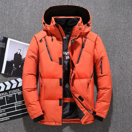 Bright orange men's winter puffer jacket displayed on a hanger with a gray fabric background and a film clapperboard beside it