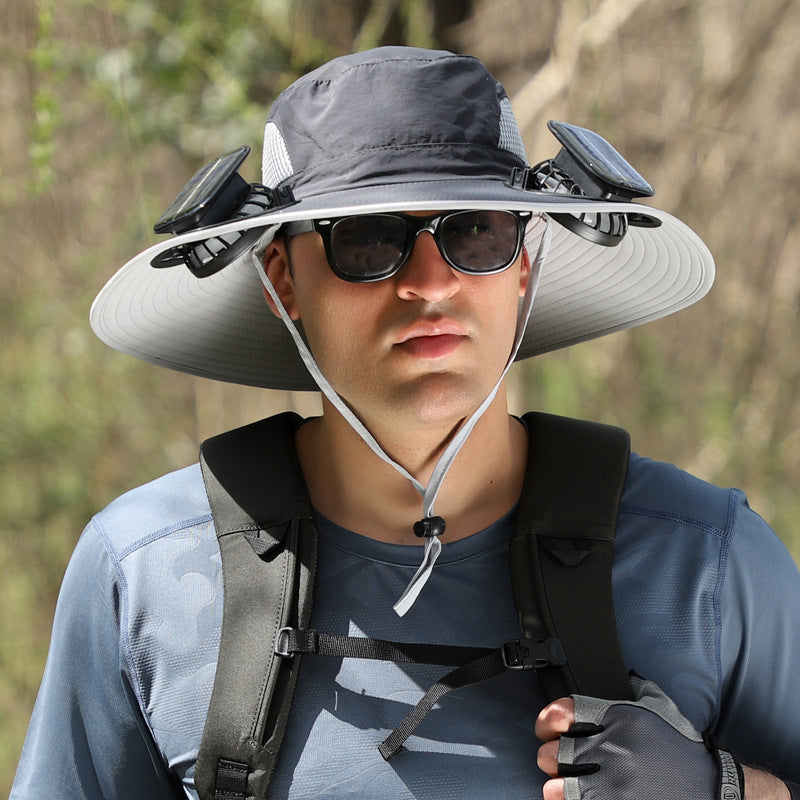 Person wearing a wide-brimmed hat with sunglasses and a neck cover, outdoors.