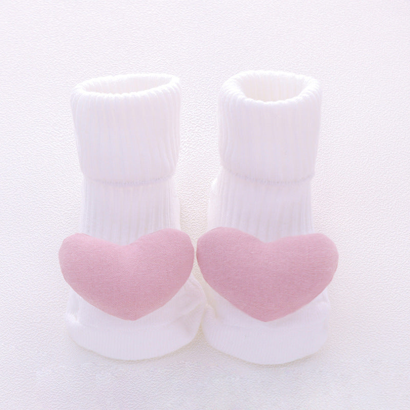 White socks with pink heart-shaped toes on a light gray background