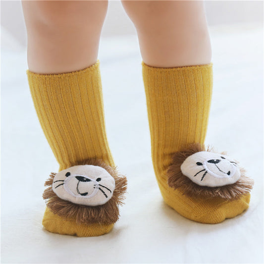 Yellow socks with lion face design worn by a child on a white background