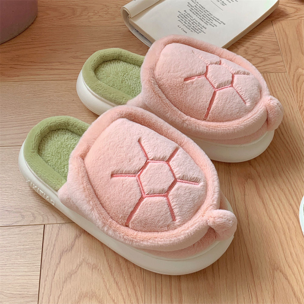Pair of pink and green slippers on a wooden floor with an open book in the background.