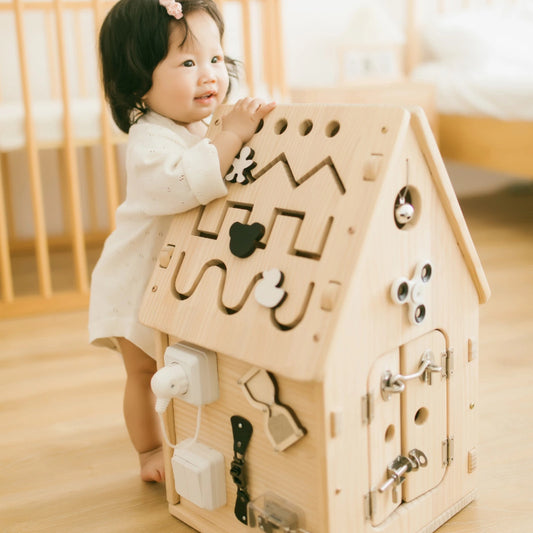 child interacting with a wooden activity house for early learning