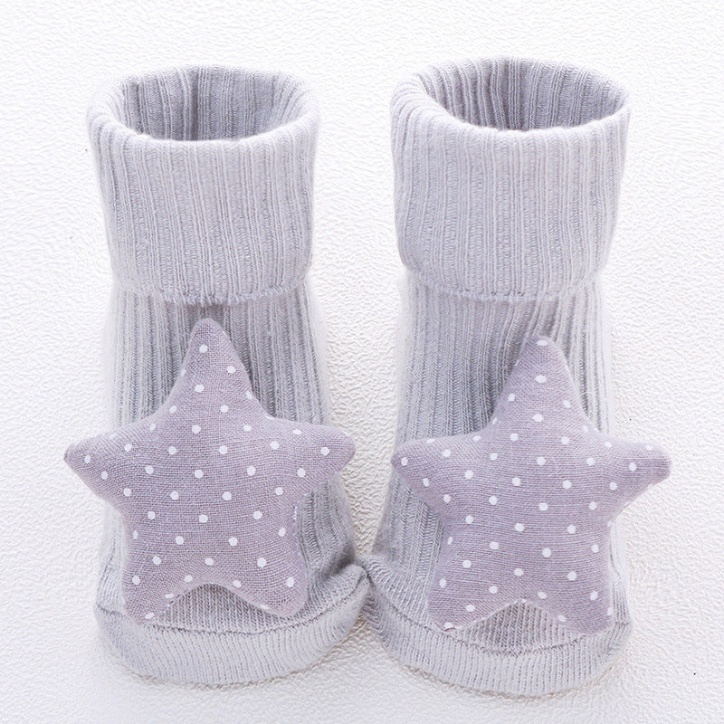 Gray baby booties with star-shaped softies on a white background