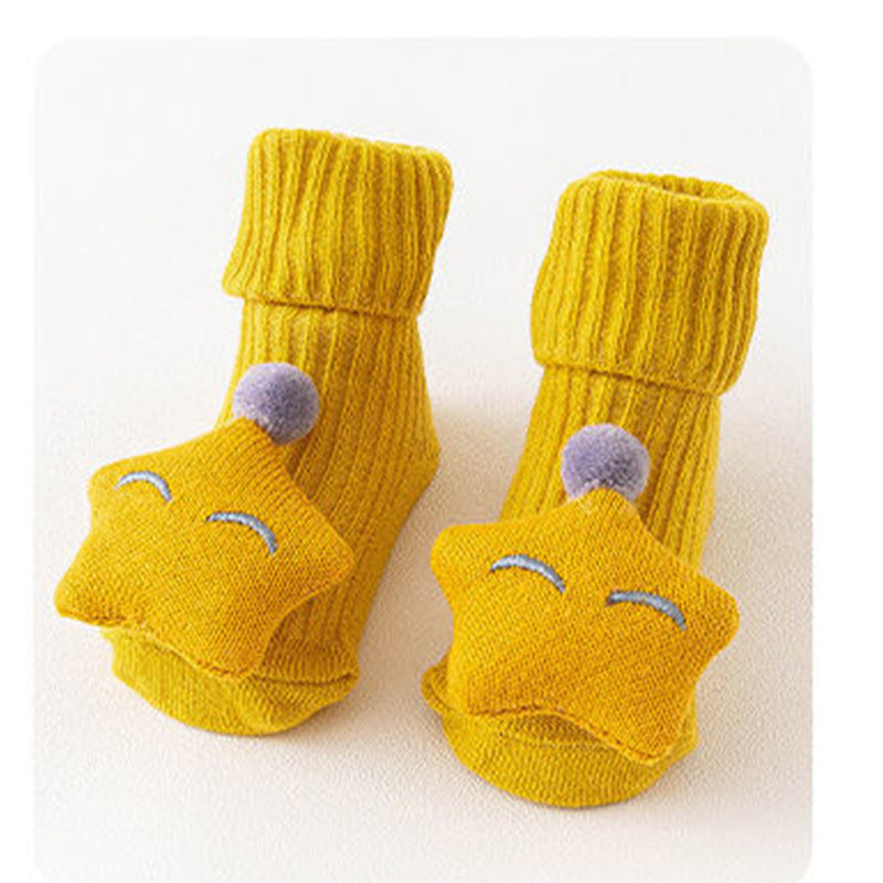 Pair of yellow baby socks with cartoon face design on a white background