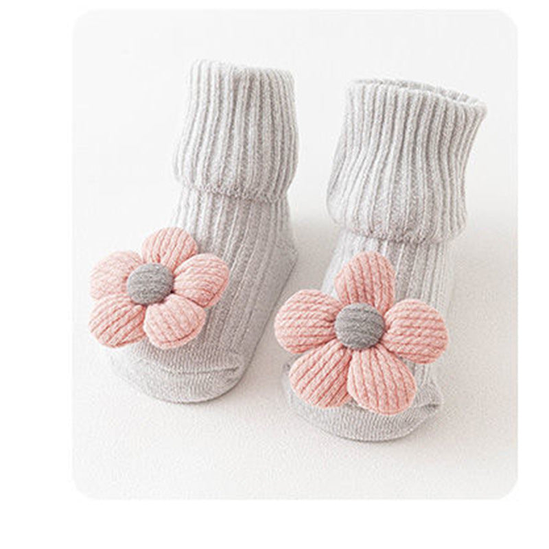 Pair of baby socks with pink flower designs on a white background